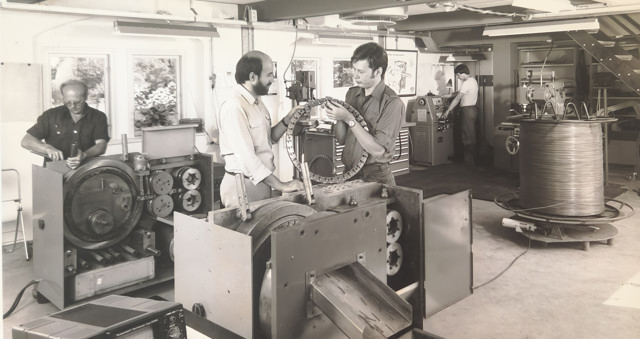 Old sepia image of an ENKOTEC rotary nail machine workshop